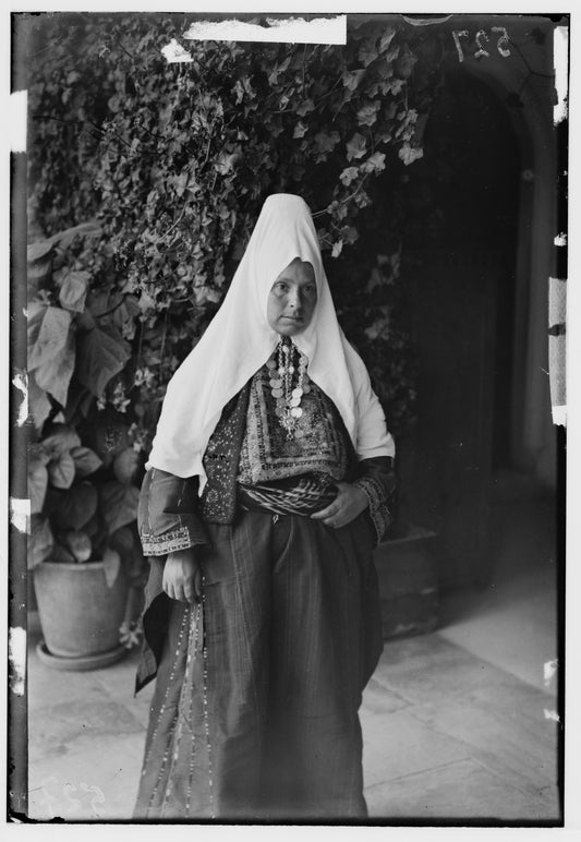 A married Bethlehem woman photographed around 1900 wearing the tall shatweh cap beneath a white veil, with a coin chin chain across her throat
