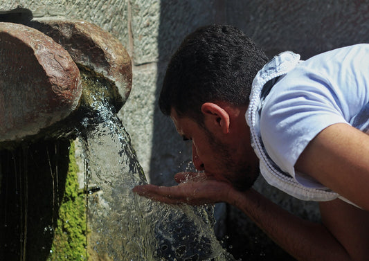 A man drinking water from the stone spring of Ain al-Balad in Battir, Palestine