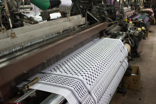 A loom weaving a traditional black and white Palestinian keffiyeh at the Hirbawi factory in Hebron