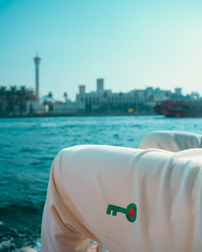 Beige pants with a green and red Palestinian key emblem on a blurred beach background