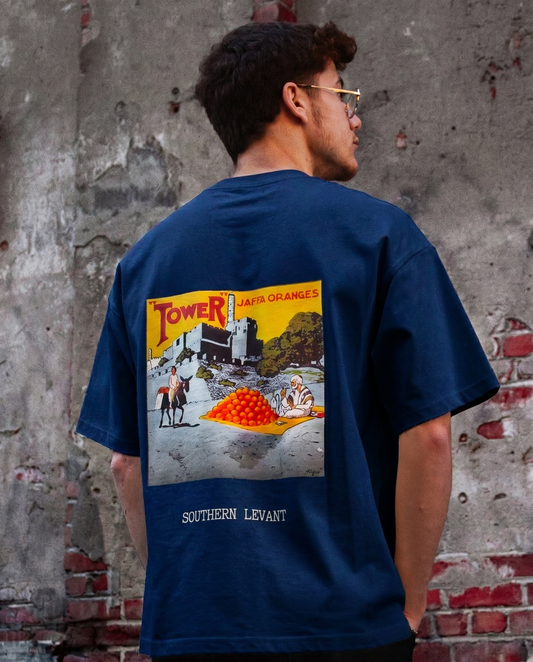 Back view of a model wearing the FALASTIN Jaffa Orange T-Shirt in Blue