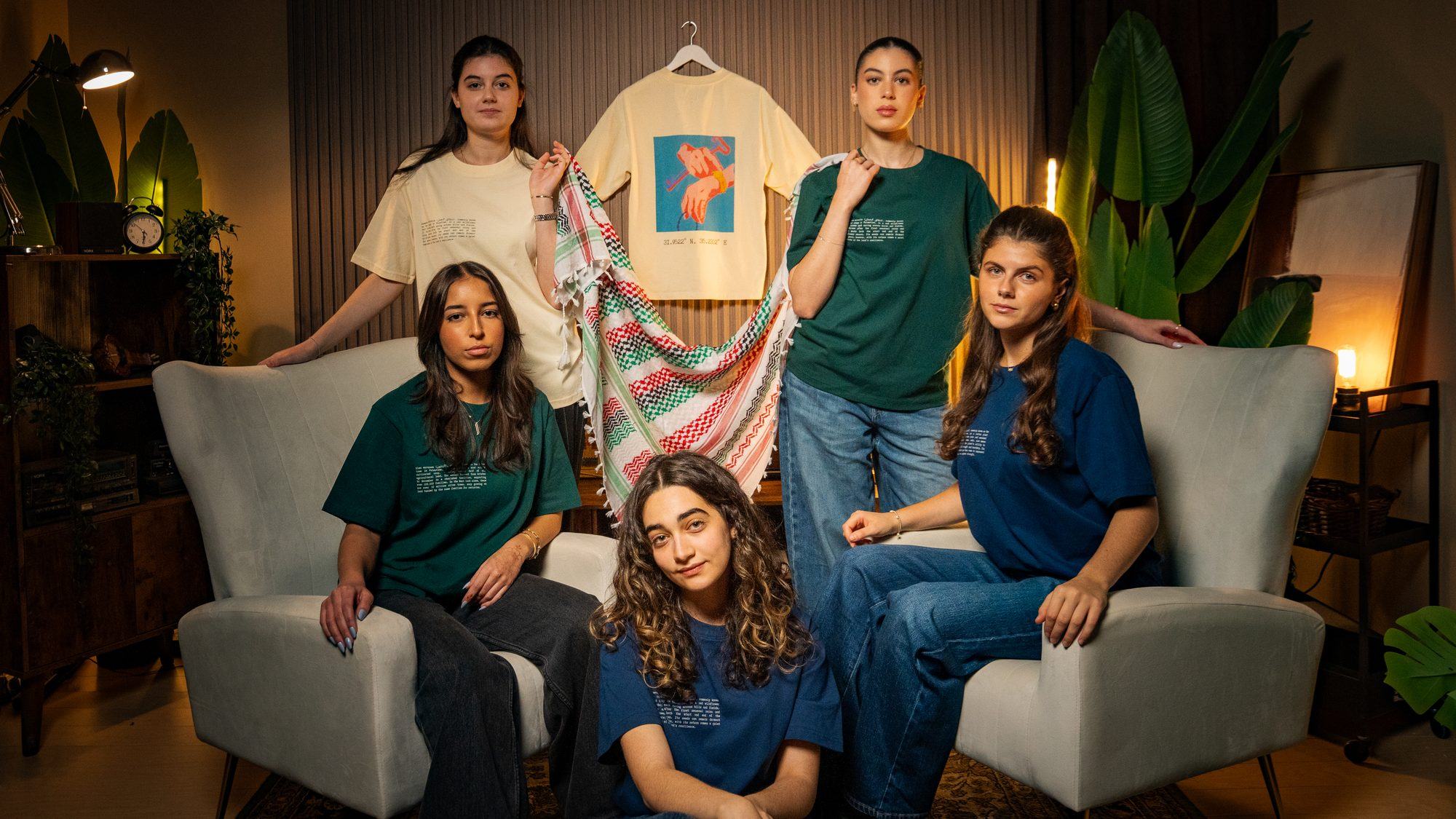 Group of women wearing FALASTIN Palestinian heritage tees and keffiyeh at desert sunset